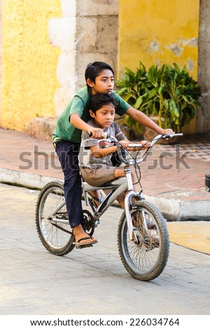 MEXICO CITY, MEXICO - DEC 29, 2011: Unidentified Mexican boys ride the bycicle. 60% of Mexican people belong to the Mestizo ethnic group