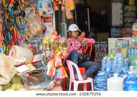SIEM RIEP, CAMBODIA - SEP 28, 2014: Unidentified Khmer girl works at a shop in Siem Reap. 90% of Cambodian people belong to Khmer etnic group