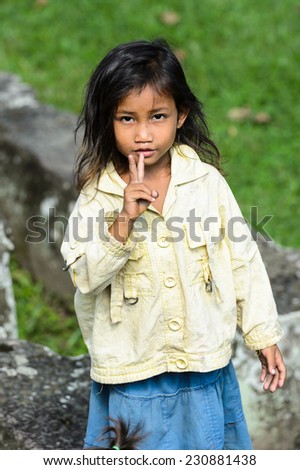 ANGKOR THOM, CAMBODIA - SEP 27, 2014: Unidentified local girl at one of the temple of Angkor Thom. Angkor Thom was the last capital city of the Khmer empire