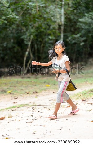 ANGKOR THOM, CAMBODIA - SEP 27, 2014: Unidentified girl at one of the temples of the Angkor Thom. Angkor Thom was the last capital city of the Khmer empire