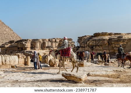 GIZA, EGYPT - NOV 23, 2014: Unidentified Egyptian man rides a camel at Giza Necropolis, Egypt. UNESCO World Heritage