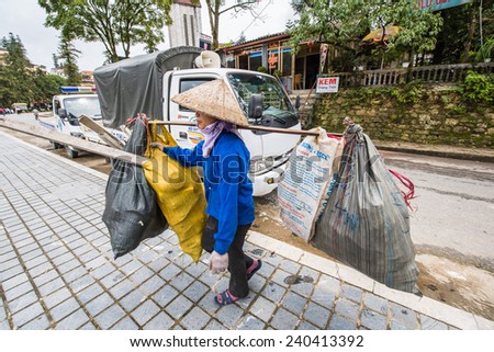 SAPA, VIETNAM - SEP 20, 2014: Unidentified Vietnamese woman cleans the street. 90% of Vietnamese people belong to the Viet ethnic group