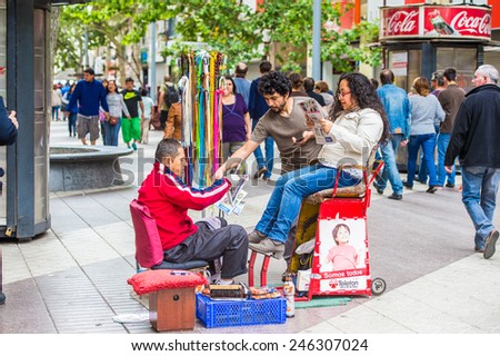 SANTIAGO, CHILE - NOV 1, 2014:  Unidentified Chilean man cleans shoes in Santiago. Chilean people are mainly of mixed Spanish and Amerindian descent