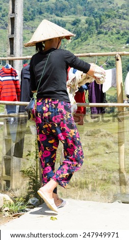 LAO CHAI VILLAGE, VIETNAM - SEP 22, 2014: Unidentified Hmong woman hangs clothes to dry in Lao Chai. Hmong is on of the minority eethnic group in Vietnam