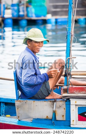 NHA TRANG, VIETNAM - SEP 30, 2014: Unidentified Vietmanese old man on a boat on the Indochina sea. 90% of the Vietnamese people belong to the Viet ethnic group