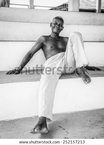 KARA, TOGO - MAR 9, 2013: Unidentified Togolese man in white pants smiles. People in Togo suffer of poverty due to the unstable econimic situation