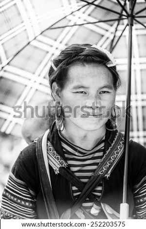 LAO CHAI VILLAGE, VIETNAM - SEP 22, 2014: Unidentified Hmong woman carries her little baby on her back in a village Lao Chai. Hmong is on of the minority eethnic group in Vietnam