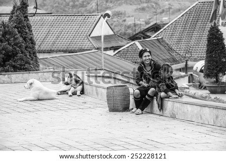 SAPA, VIETNAM - SEP 20, 2014: Unidentified Hmong woman sewing and her little daughter helps her. Hmong people is a minority ethnic group living in Sapa