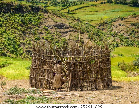 OMO, ETHIOPIA - SEPTEMBER 21, 2011: Unidentified Ethiopian woman constructs a wooden cabin. People in Ethiopia suffer of poverty due to the unstable situation