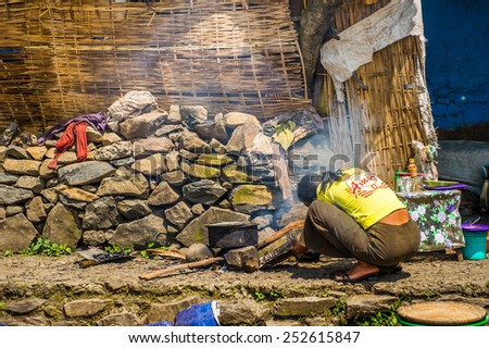 OMO, ETHIOPIA - SEPTEMBER 21, 2011: Unidentified Ethiopian woman cooks. People in Ethiopia suffer of poverty due to the unstable situation
