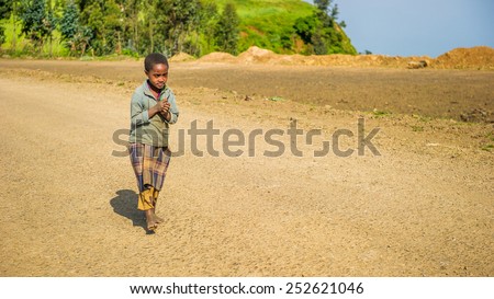 OMO, ETHIOPIA - SEPTEMBER 21, 2011: Unidentified Ethiopian boy runs in the street. People in Ethiopia suffer of poverty due to the unstable situation