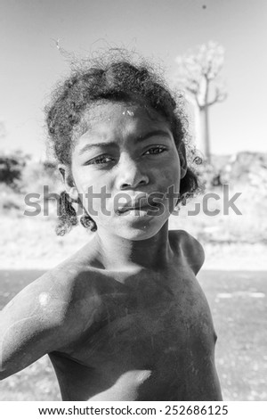 ANTANANARIVO, MADAGASCAR - JULY 3, 2011: Unidentified Madagascar boy runs near a road. People in Madagascar suffer of poverty due to slow development of the country