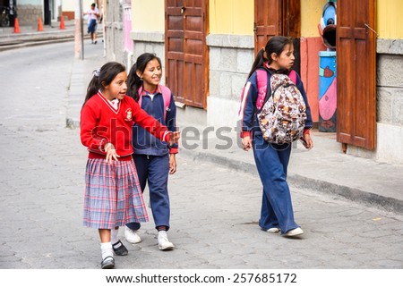 RIOBAMBA, ECUADOR - JAN 7, 2015: Unidentified Ecuadorian school girls walk in the street. 71,9% of Ecuadorian people belong to the Mestizo ethnic group