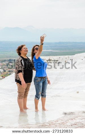 PAMUKKALE, TURKEY - APR 18, 2015: Unidentified girl makes selfie on the travertines of Pamukkale, Turkey. It\'s a UNESCO World Heritage site