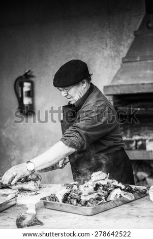 PATAGONIA, CHILE - NOV 6, 2014:  Unidentified Chilean man preapares a traditional national food of Chile Asado. Chilean people are of mixed Spanish and Amerindian descent