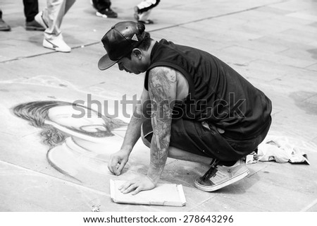 SANTIAGO, CHILE - NOV 1, 2014:  Unidentified Chilean man draws a Jesus Christ image on the ground in Santiago. Chilean people are mainly of mixed Spanish and Amerindian descent