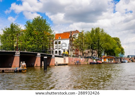 AMSTERDAM, NETHERLANDS - JUN 1, 2015: Architecture on the Canal of Amsterdam. Amsterdam is the capital city and most populous city of the Kingdom of the Netherlands