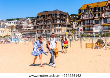 TROUVILLE, FRANCE - JUN 7, 2015:  Unidentified tourists on the coast of Trouville, Normandy, France. Trouville is a village of fishermen and a popular tourist attraction in Normandy