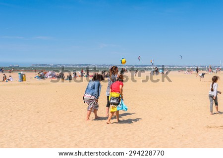 TROUVILLE, FRANCE - JUN 7, 2015:  Unidentified tourists on the coast of Trouville, Normandy, France. Trouville is a village of fishermen and a popular tourist attraction in Normandy