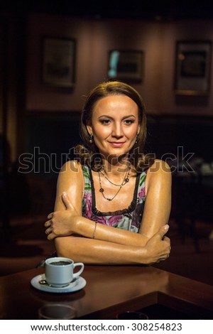 PRAGUE, CZECH REPUBLIC - JUNE 29, 2015: Wax woman drinks coffee in Grevin museum. Grevin is the museum of the wax figures in Prague