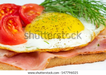 Sandwich with fried eggs, ham and tomatoes