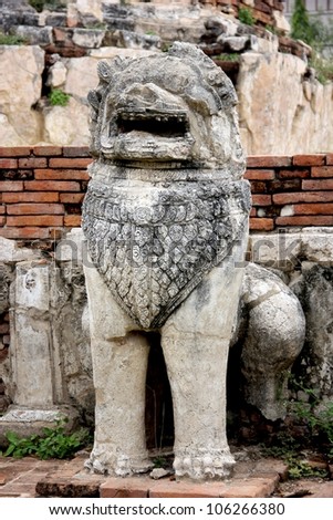 One of stone lions at the base of a pagoda in a Thai ancient temple\'s ruins, Ayutthaya, Thailand.