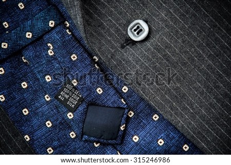 Reverse of blue silk tie with men\'s black woolen suit.