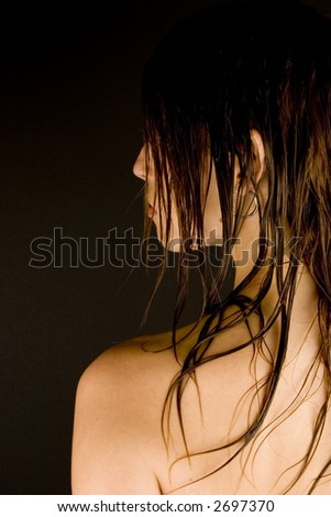 The back of a young woman\'s head with wet hair against a plain background.