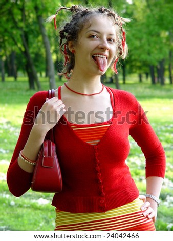 A smiling girl with plaits and showing tongue in red clothes with stripes