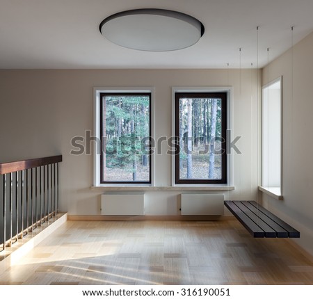 Interior of modern empty space with suspended bench and big windows