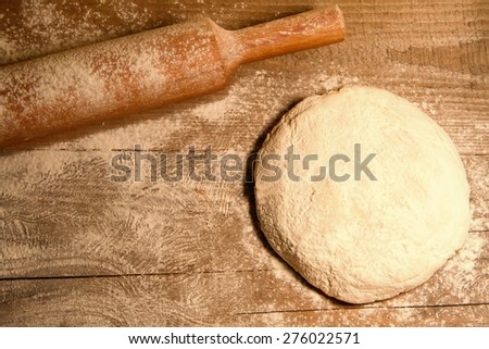 homemade baking. Fresh dough for pastry, spilled flour, kitchen rolling pin on a chopping old Board