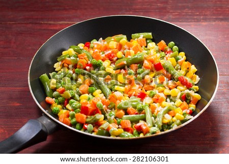 vegetable mix in the pan on wooden background