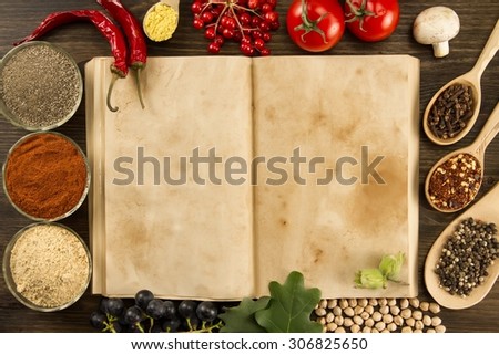 open old vintage book with spices on wooden background. Healthy vegetarian food. Recipe, menu, mock up, cooking.