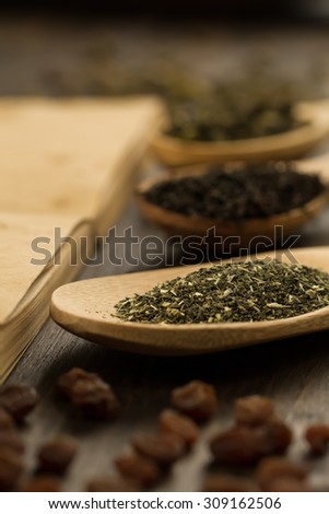 tea collection, flowers, old blank open book on wooden background. Menu, recipe, mock up