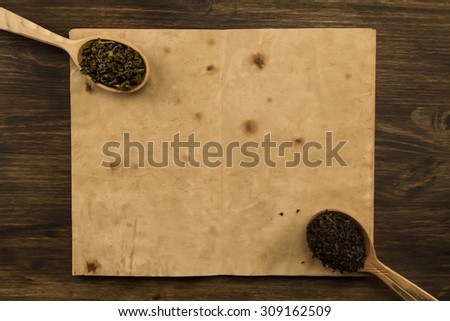 black, Oolong tea spoon in the old blank open book on wooden background. Menu, recipe, mock up