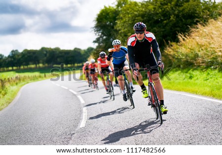 Similar – Image, Stock Photo Group of cyclist friends riding race bike on sunset highway, sunset bike competition.