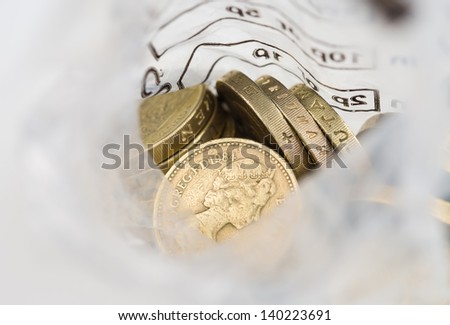 Looking down into an open money bag of pound coins