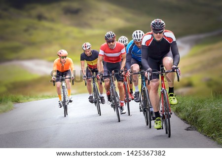 Similar – Image, Stock Photo Group of cyclist friends riding race bike on sunset highway, sunset bike competition.