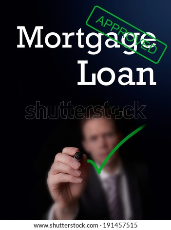 An underwriter writing Mortgage Loan approved on a screen.