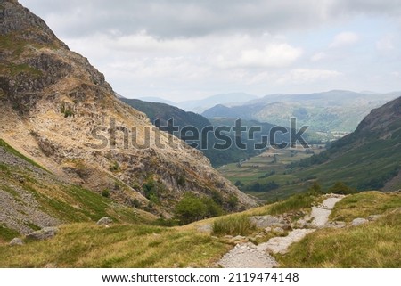 Distant mountain views of Blencathra, Bleaberry Fell, Grange Fell and Seatoller from a rocky trail below Base Brown in the English Lake District, UK. 商業照片 © 