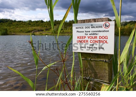 A sign warning owners to Keep their dog under control at a wildlife conservation park.
