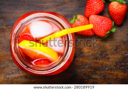 Strawberry lemonade, beverage.Fruit infused water with strawberries and lemon in mason jar on dark rustic wood background.