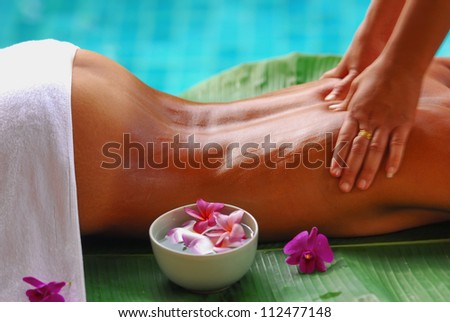 Women tan color skin oil massage in the spa An attractive tan woman lying down on a massage bed at a spa for oily massage