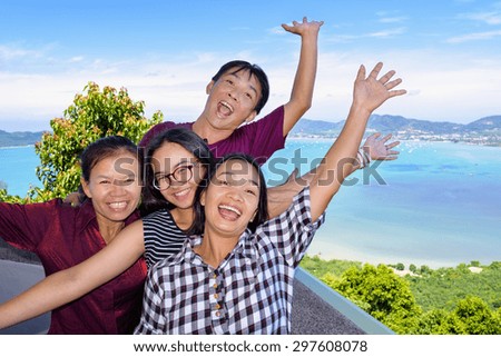 Family of tourists smiling are happy and show their hands invite to see the beautiful landscape of sea on Khao-Khad mountain viewpoint famous attractions in Phuket Province, Thailand