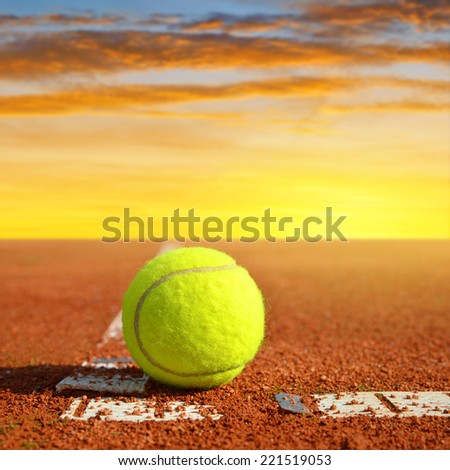Tennis ball on a tennis clay court in the sunset