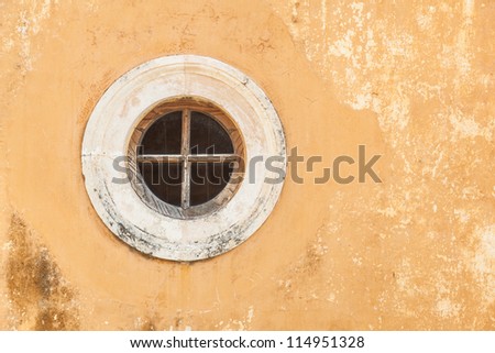 Old antique round window in an dirty wall of the Greece monastery. Agia Triada. Crete.
