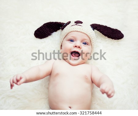 Funny happy newborn boy in rabbit hat with ears