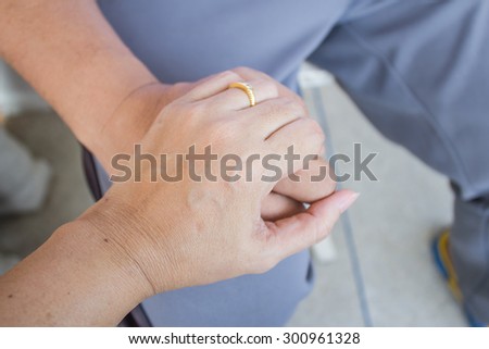 Hands of wife holding the hand of her husband to give spirit