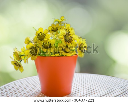 yellow fabric flower on abstract bokeh blur background of nature