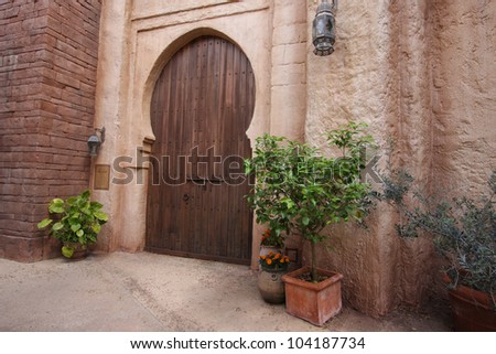 A pink coloured exterior wall with large wooden door, Arab country, travel shot.